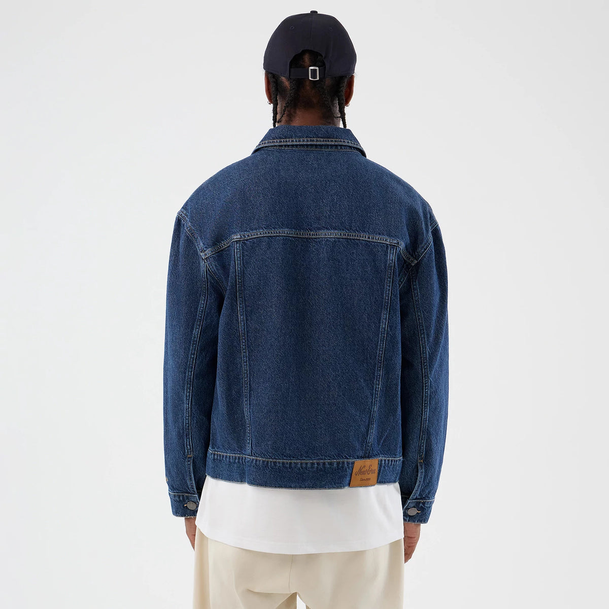 The model is wearing this New Era Script Denim Jacket in dark blue. 2
