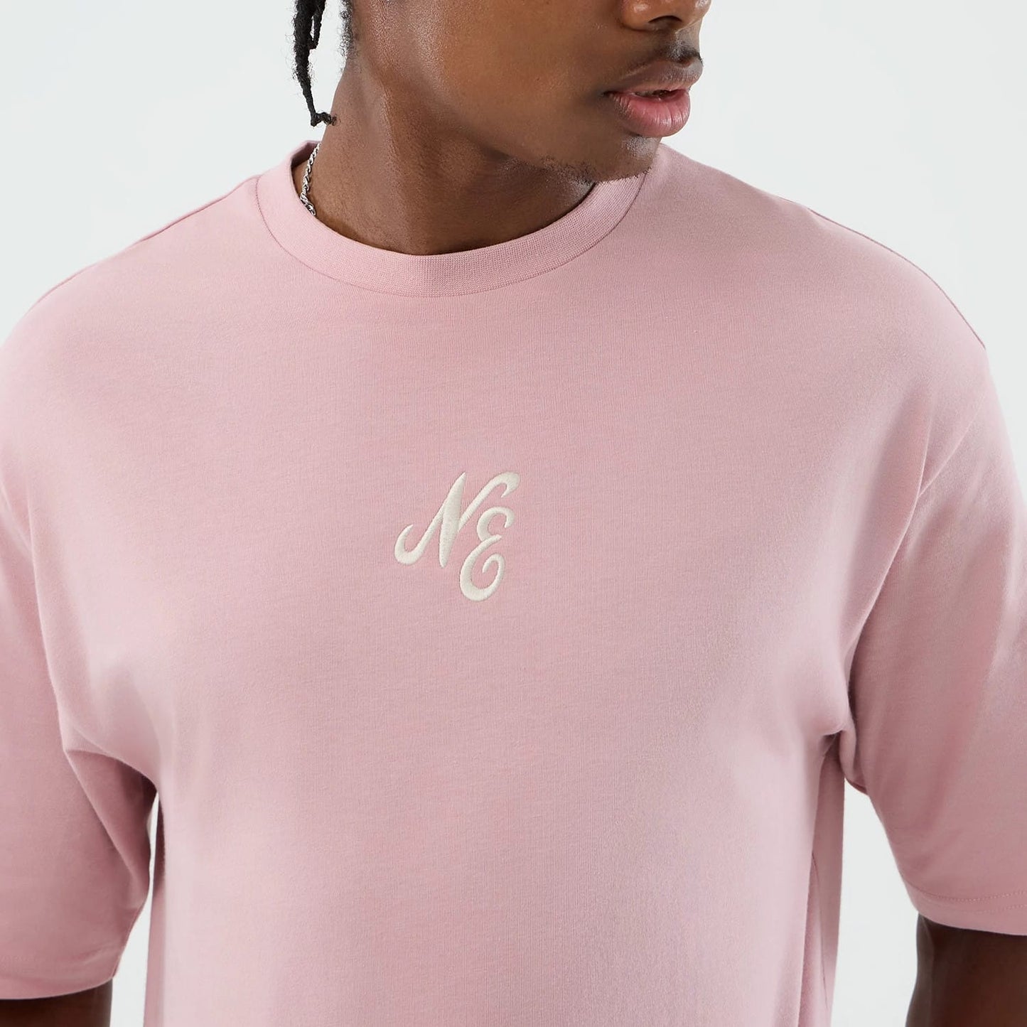 The model is wearing this New Era Floral Graphic Oversized T-Shirt in pastel pink. 5