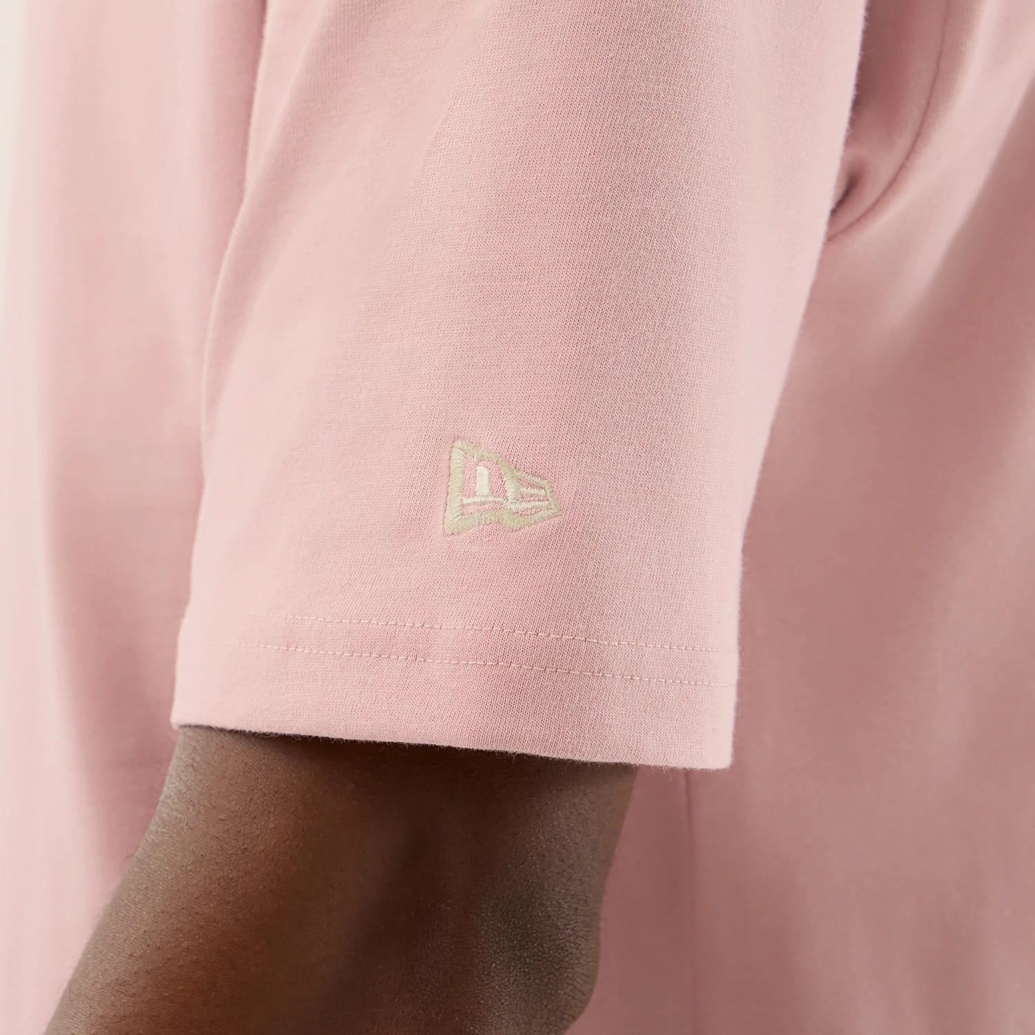The model is wearing this New Era Floral Graphic Oversized T-Shirt in pastel pink. 7
