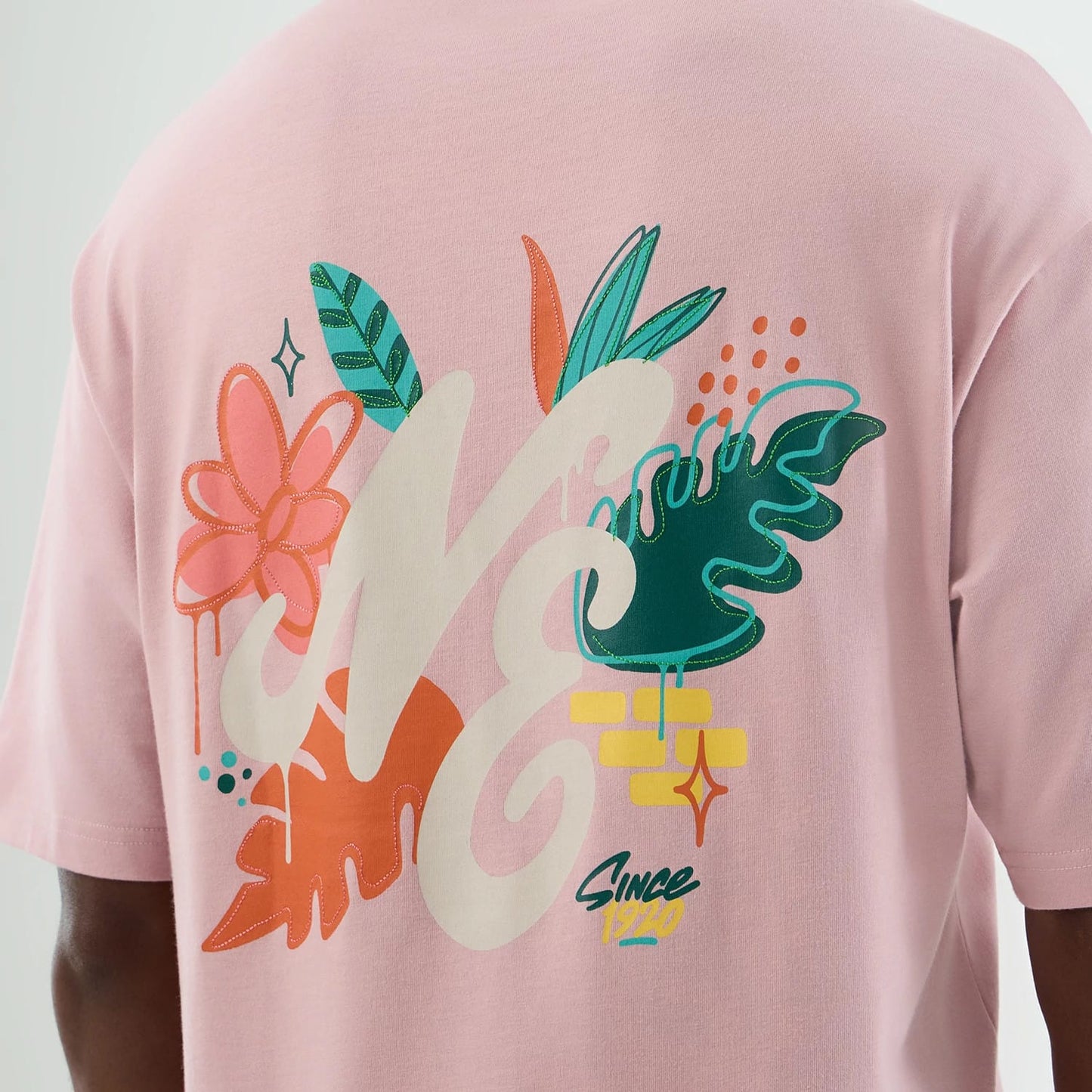 The model is wearing this New Era Floral Graphic Oversized T-Shirt in pastel pink. 8