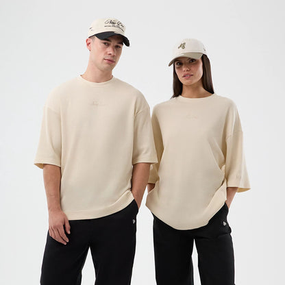 The model is wearing this New Era Waffle T-Shirt in light beige. 1