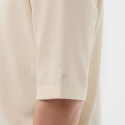 The model is wearing this New Era Waffle T-Shirt in light beige. 7