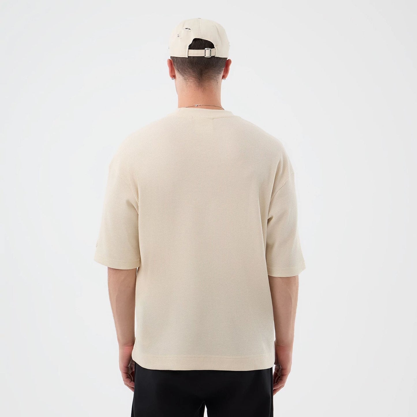 The model is wearing this New Era Waffle T-Shirt in light beige. 2