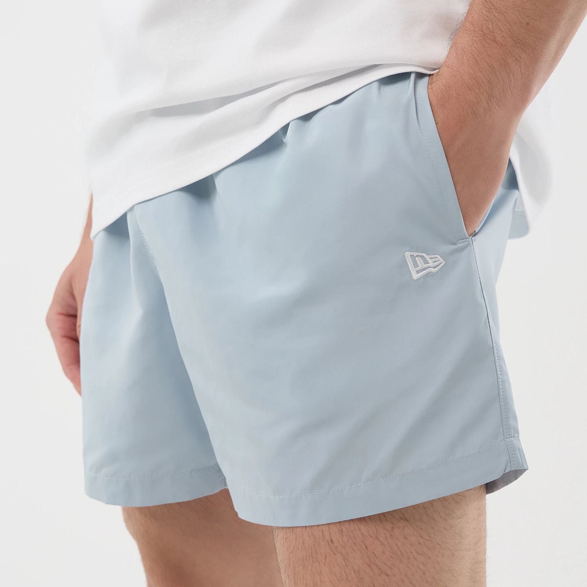 The model is wearing this New Era Swimming Shorts in pastel blue. 4