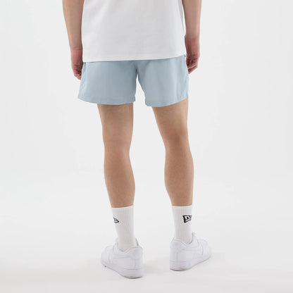The model is wearing this New Era Swimming Shorts in pastel blue. 2