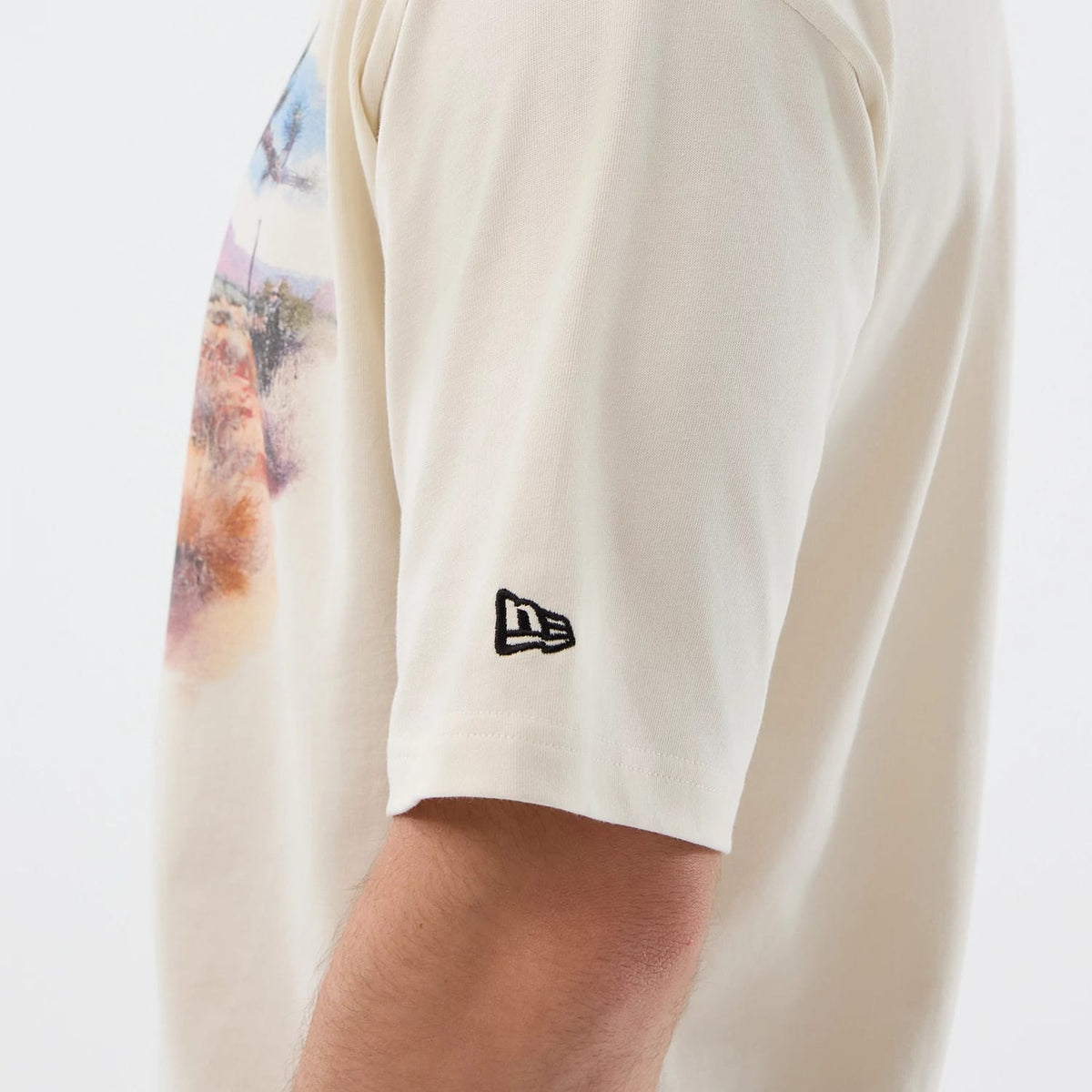 The model is wearing this New Era Dessert Graphic Oversized T-Shirt in light beige. 7