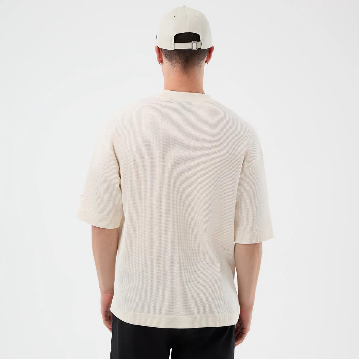 New Era New York Yankees MLB Waffle Open White T-Shirt, back view on a model wearing a matching cap, showing the plain white textured fabric with short sleeves, a relaxed fit, and a small embroidered logo near the bottom of the left sleeve.