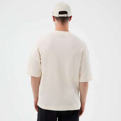 New Era New York Yankees MLB Waffle Open White T-Shirt, back view on a model wearing a matching cap, showing the plain white textured fabric with short sleeves, a relaxed fit, and a small embroidered logo near the bottom of the left sleeve.