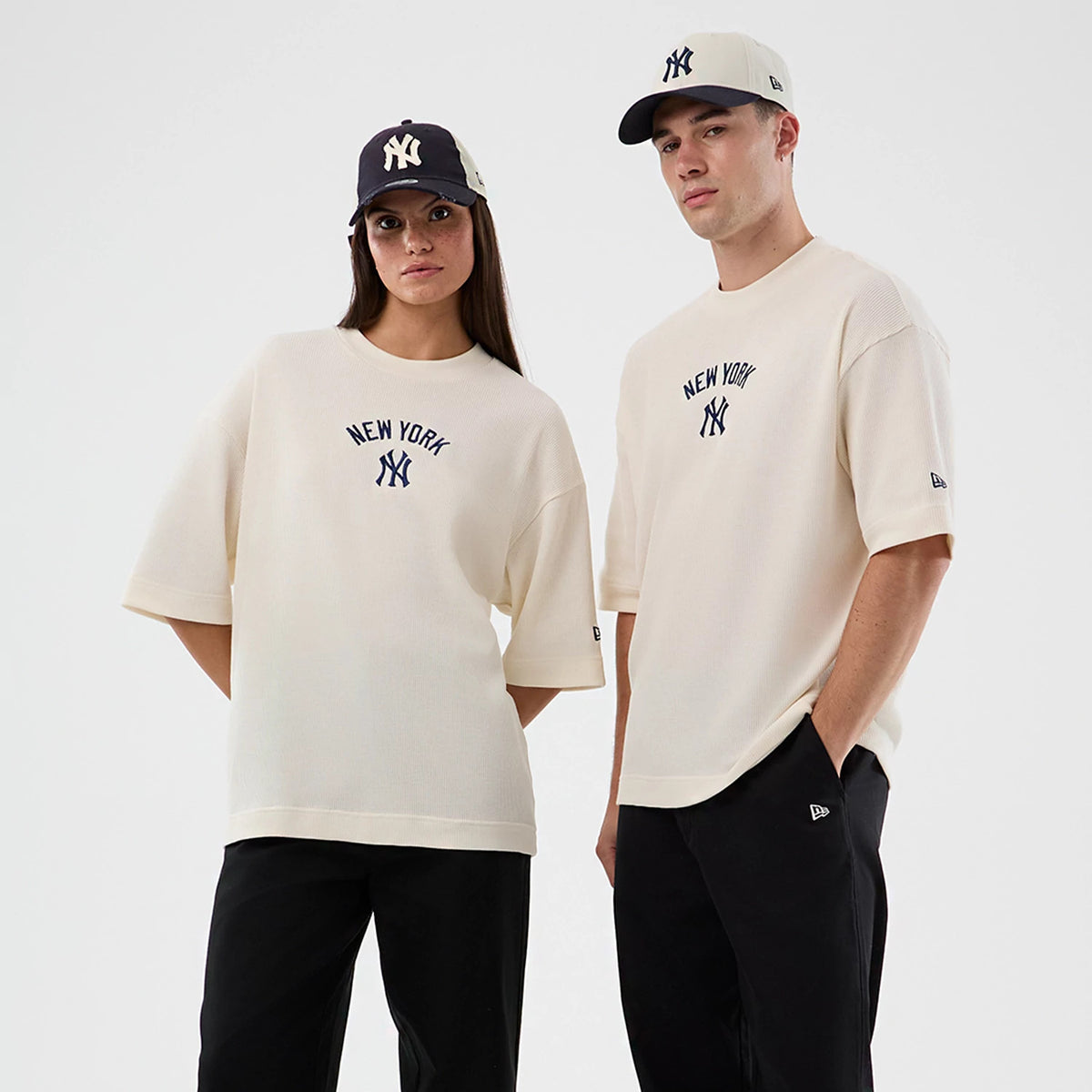 New Era New York Yankees MLB Waffle Open White T-Shirt, front view on models wearing complementary caps, featuring embroidered New York Yankees lettering and logo centred on the chest and a small embroidered New Era flag logo on the left sleeve.