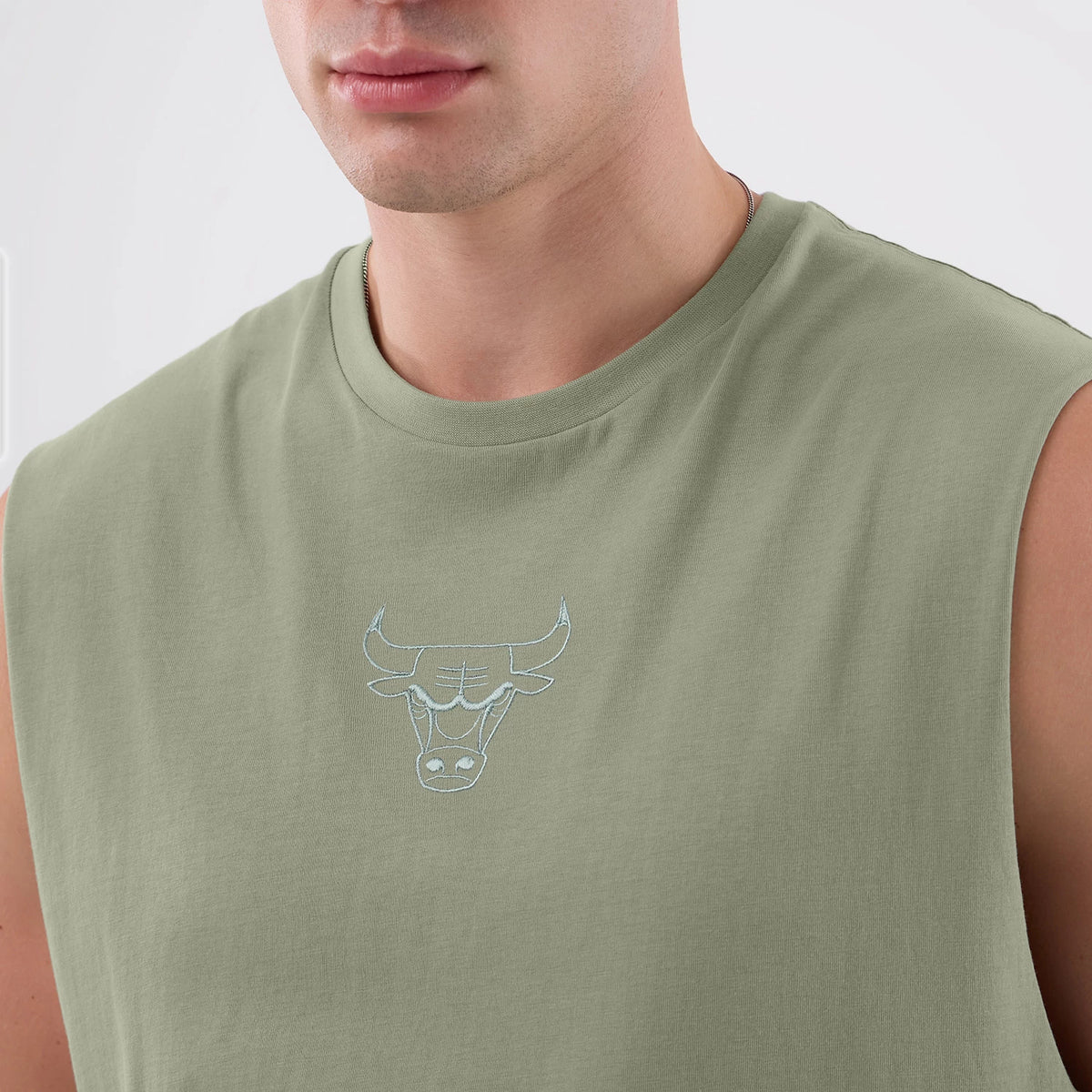 New Era Chicago Bulls NBA League Essential Pastel Green Vest, front view on a model showing the light blue embroidered Bulls logo centred on the chest, sleeveless design with a round collar and pastel green fabric.