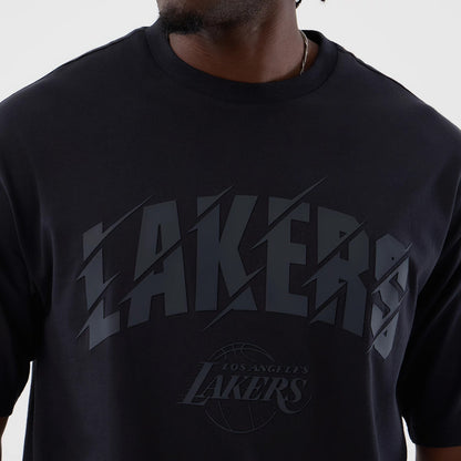 New Era LA Lakers NBA Core Plus Navy Oversized T-Shirt, front view showing oversized navy tee with raised LAKERS text across the chest in dark blue, layered graphic of a basketball beneath, on model with minimal accessories.