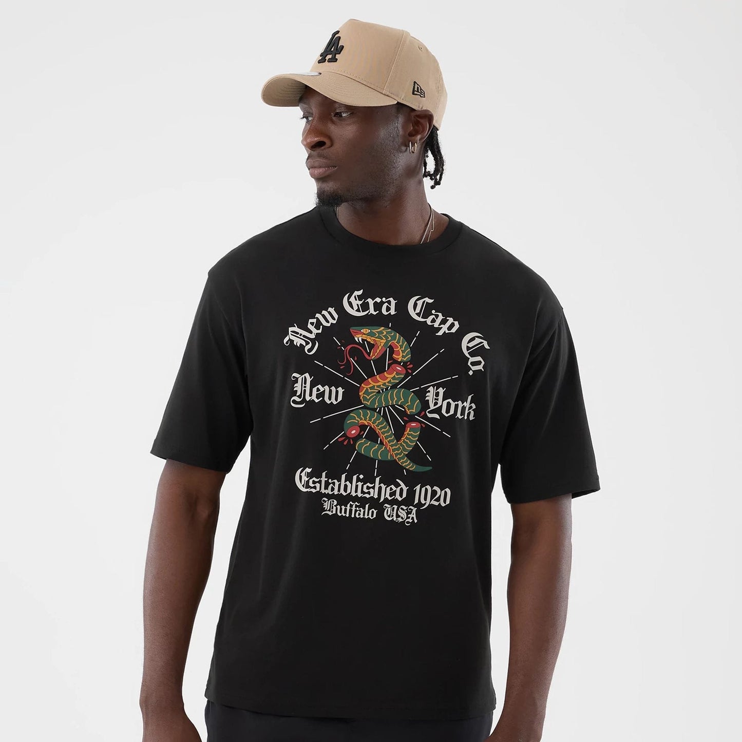 The model is wearing this New Era Serpent Graphic Oversized T-Shirt in black. 3