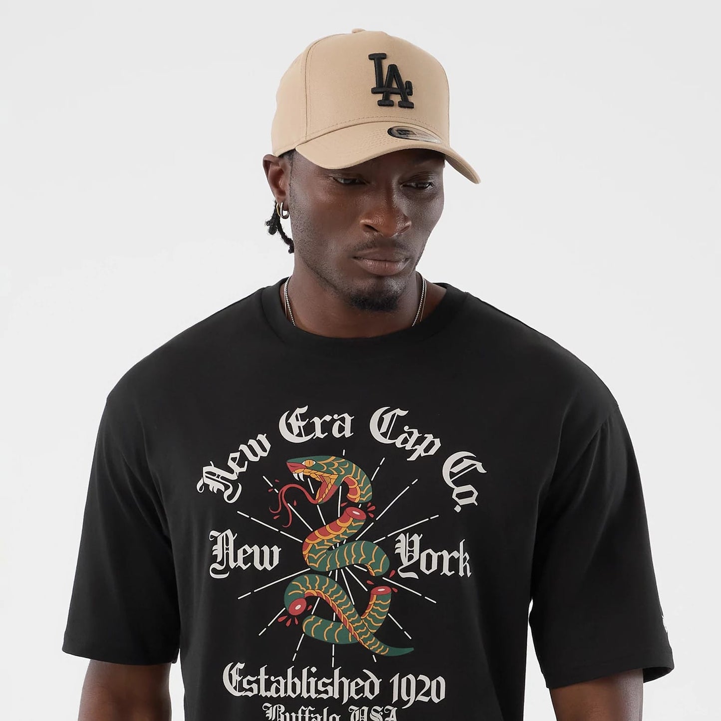 The model is wearing this New Era Serpent Graphic Oversized T-Shirt in black. 6