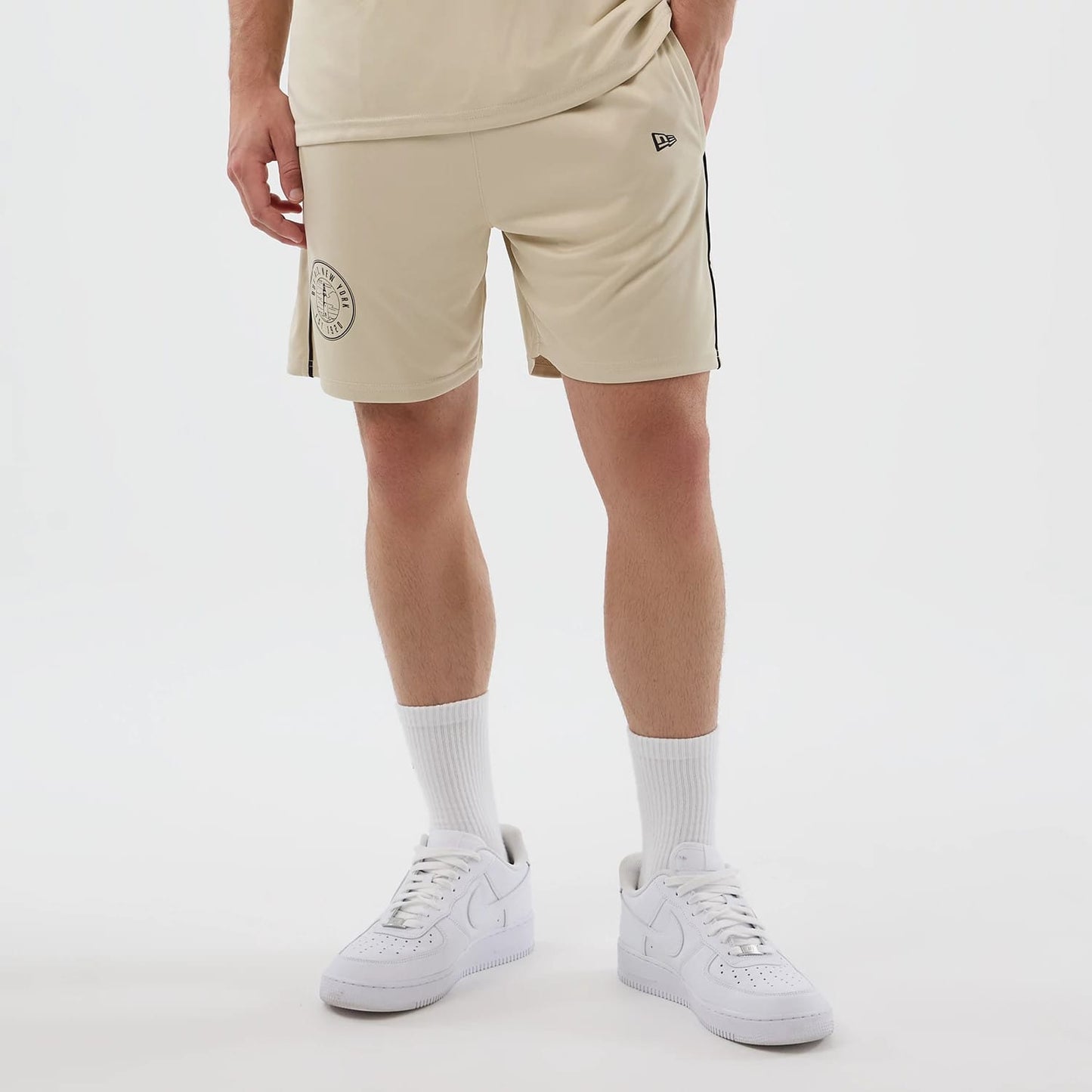 The model is wearing these New Era Football Shorts in light beige. 7