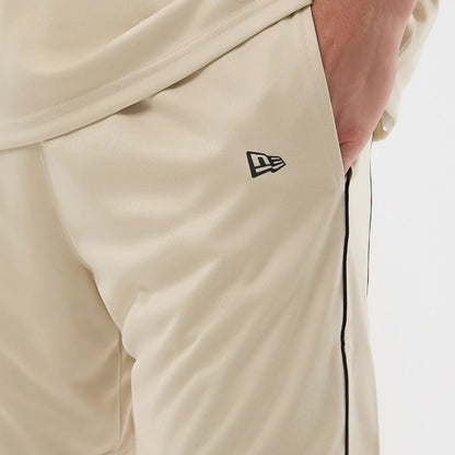 The model is wearing these New Era Football Shorts in light beige. 4