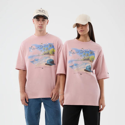 The model is wearing this New Era Beach Graphic Oversized T-Shirt in pastel pink. 1