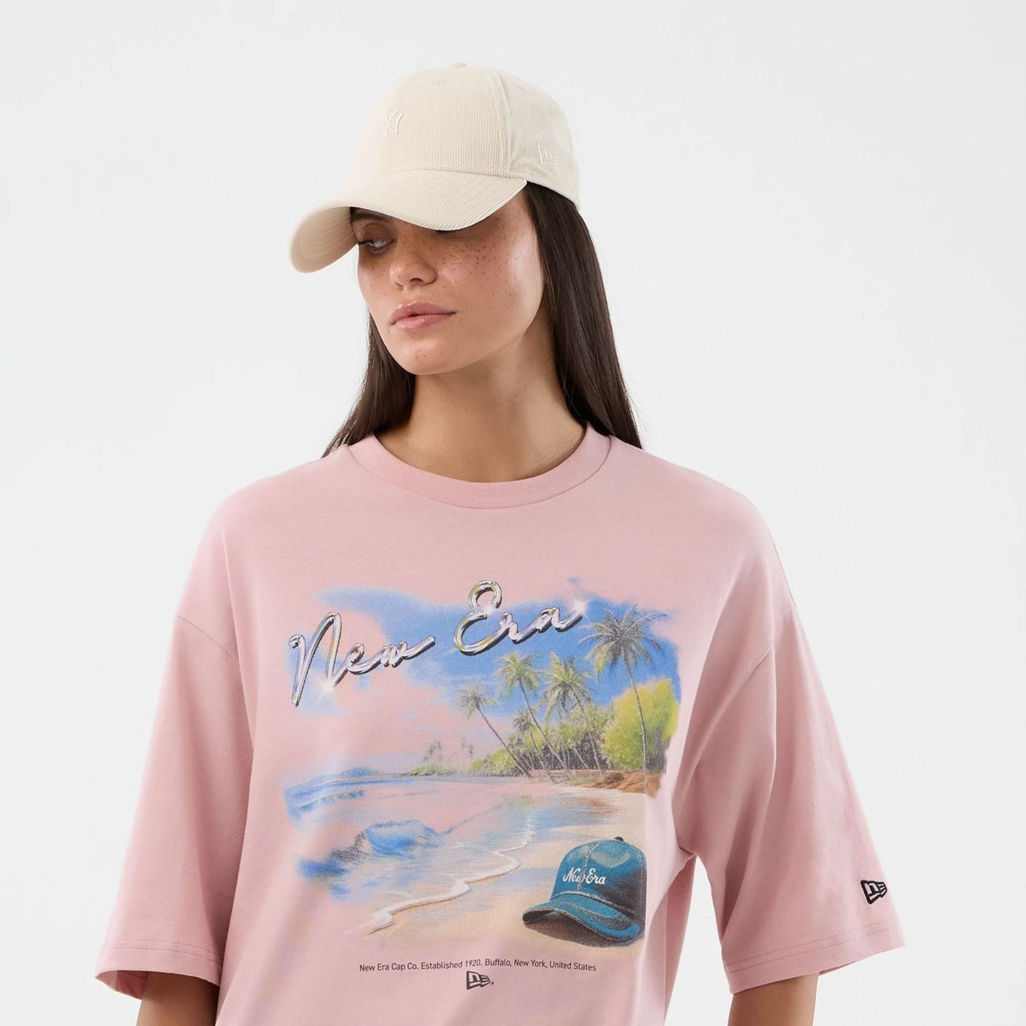 The model is wearing this New Era Beach Graphic Oversized T-Shirt in pastel pink. 6