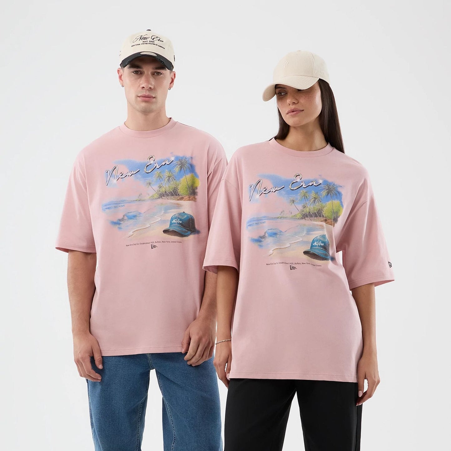 The model is wearing this New Era Beach Graphic Oversized T-Shirt in pastel pink. 1