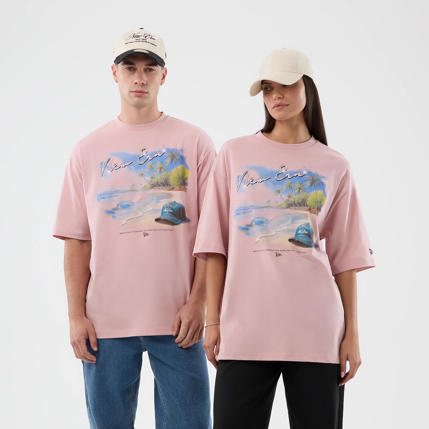 The model is wearing this New Era Beach Graphic Oversized T-Shirt in pastel pink. 1