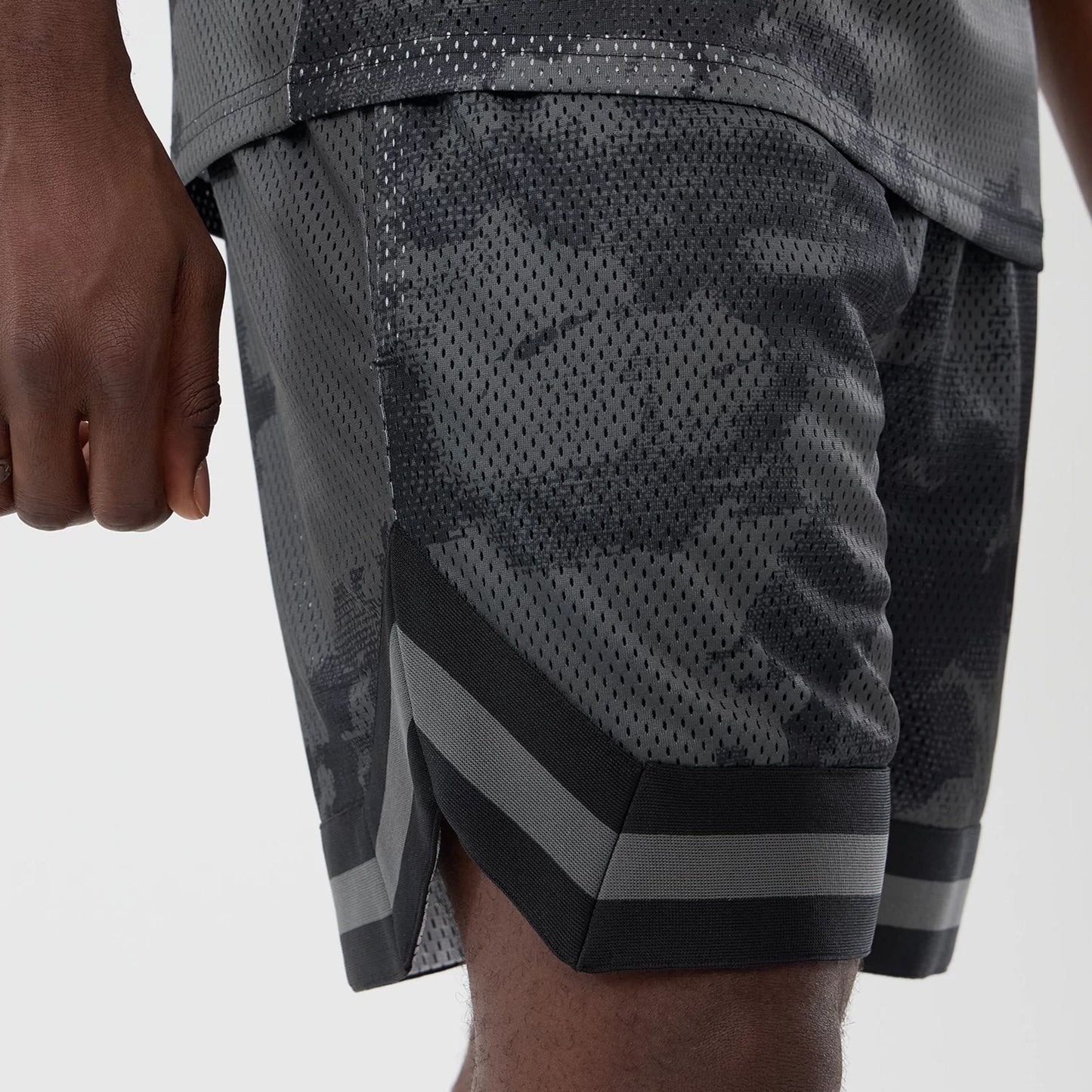The model is wearing this New Era All Over Print Mesh Shorts in black camo. 3