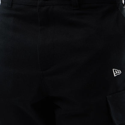 New Era Black Cargo Shorts, close-up view showing the waistband with belt loops, a seam at the centre, and a white embroidered New Era logo on the right side above a large cargo pocket.