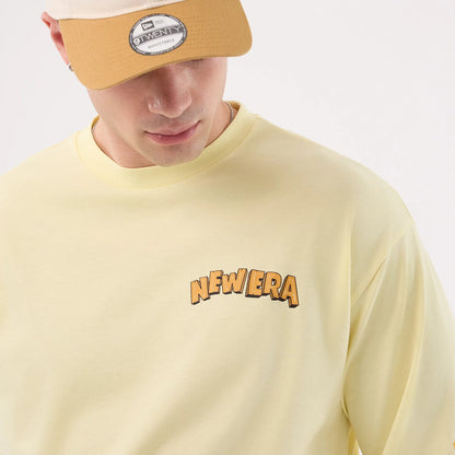 The model is wearing this New Era Fun Beach Party Graphic Oversized T-Shirt in pastel yellow. 6