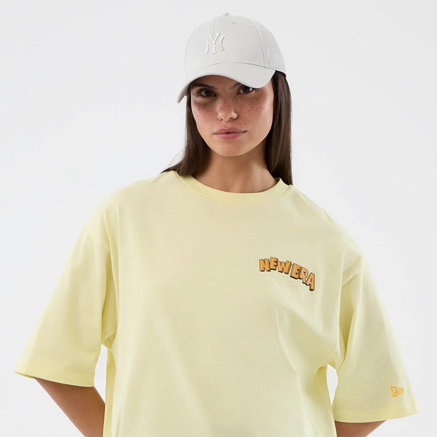 The model is wearing this New Era Fun Beach Party Graphic Oversized T-Shirt in pastel yellow. 7