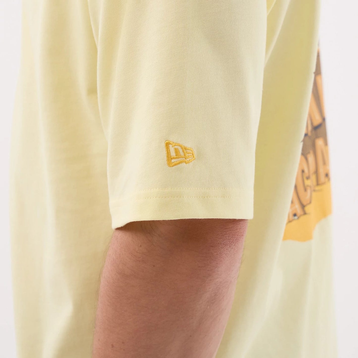 The model is wearing this New Era Fun Beach Party Graphic Oversized T-Shirt in pastel yellow. 8