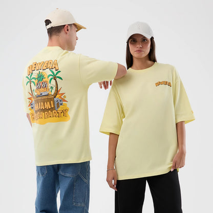 New Era Fun Beach Party Graphic Pastel Yellow Oversized T-Shirt, on-model view featuring New Era lettering with palm trees and speakers across the back, smaller embroidered New Era logo on the front, and worn with casual trousers and a cap.