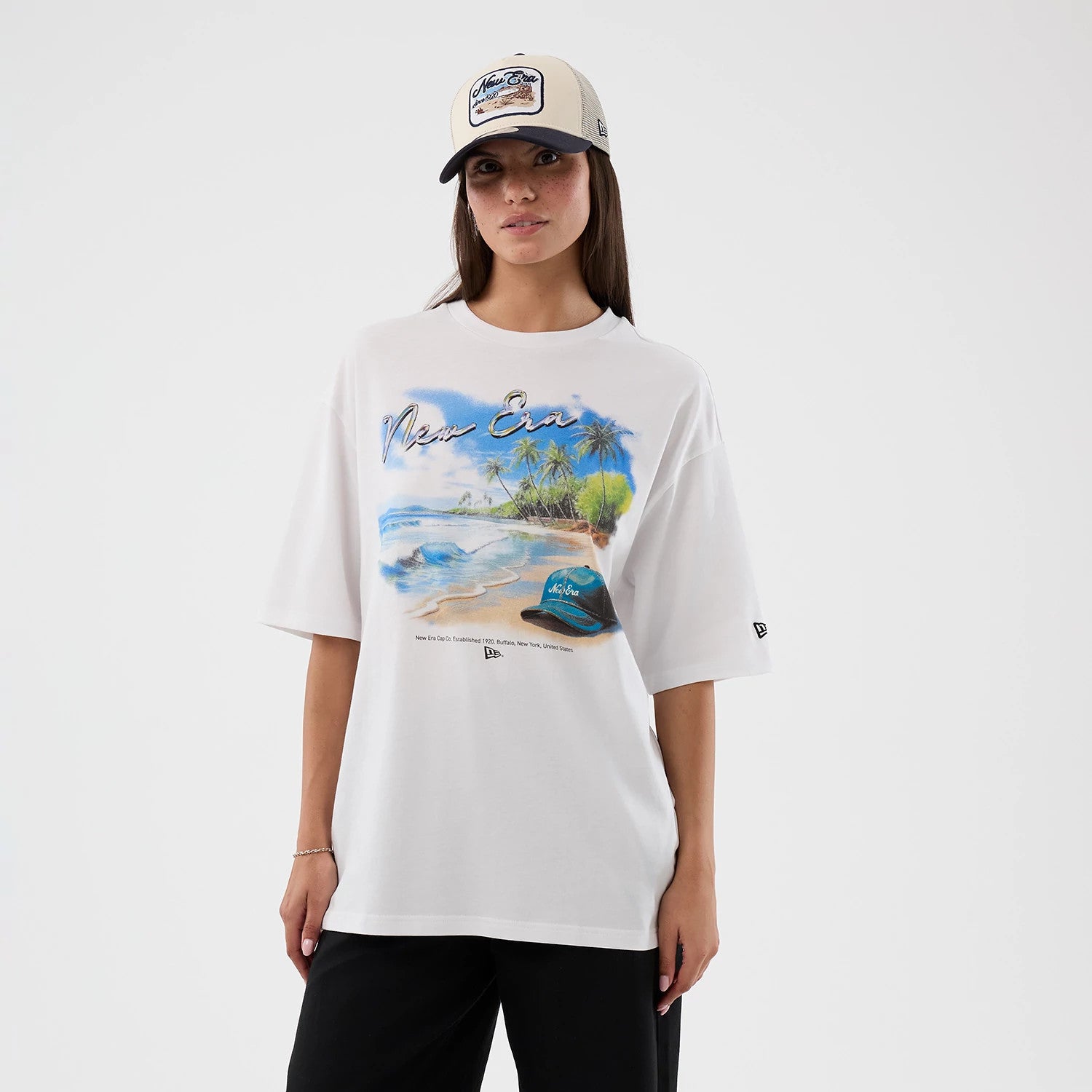 The model is wearing this New Era Beach Graphic Oversized T-Shirt in white. 4