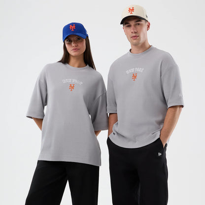 New Era New York Mets MLB Waffle Grey T-Shirt, on-model front view featuring a grey oversized fit with New York embroidered across the chest, a Mets logo below in orange, and another small New Era logo embroidered on the left sleeve.