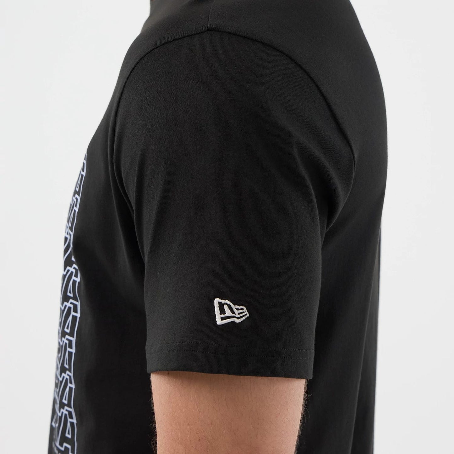 The model is wearing this New Era Logo Graphic T-Shirt in black. 5