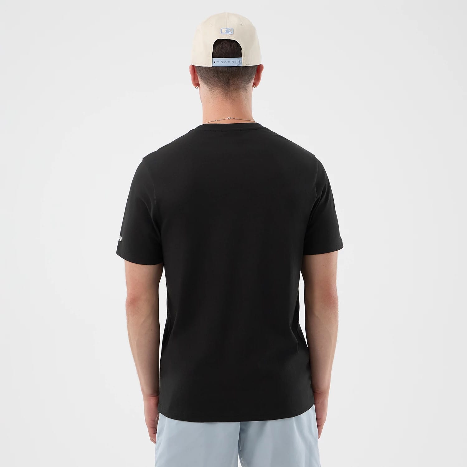 The model is wearing this New Era Logo Graphic T-Shirt in black. 2