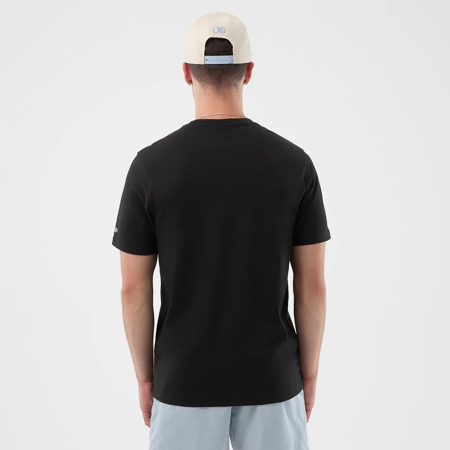 The model is wearing this New Era Logo Graphic T-Shirt in black. 2