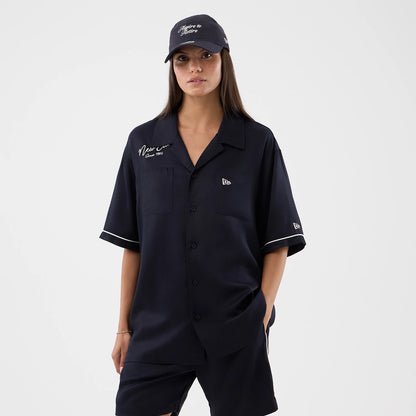 The model is wearing this New Era Graphic Revere Short Sleeve Shirt in navy. 4
