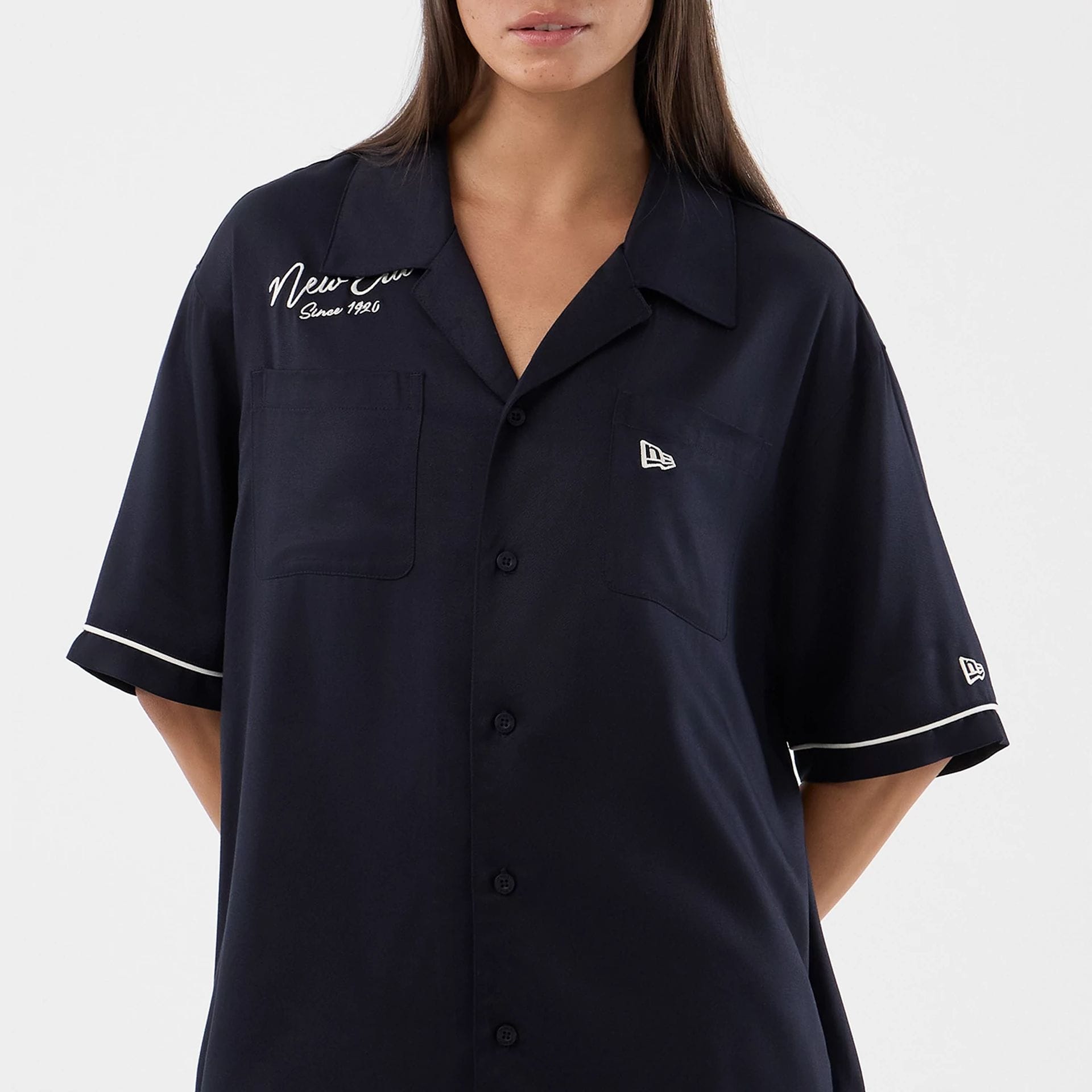 The model is wearing this New Era Graphic Revere Short Sleeve Shirt in navy. 7