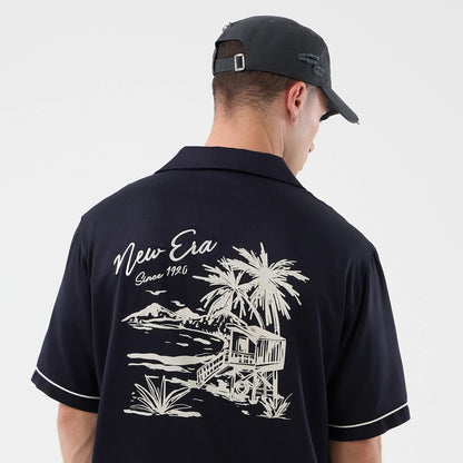 The model is wearing this New Era Graphic Revere Short Sleeve Shirt in navy. 5