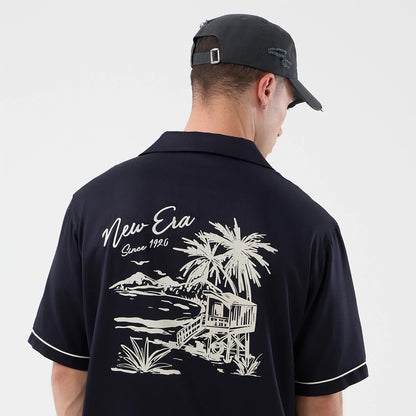 The model is wearing this New Era Graphic Revere Short Sleeve Shirt in navy. 5