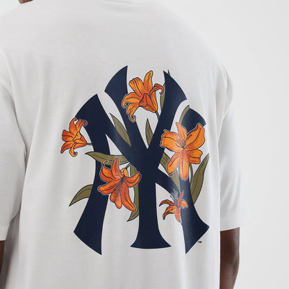 New Era New York Yankees MLB Floral White Oversized T-Shirt, back view showing a large navy blue Yankees logo adorned with orange lilies and green leaves, centrally positioned on the oversized white fabric of the shirt.