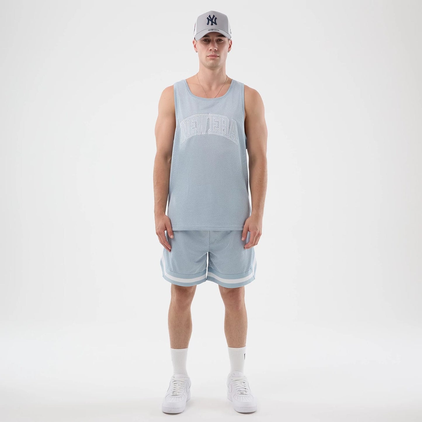 The model is wearing this New Era Mesh Oversized Tank Top in pastel blue. 8