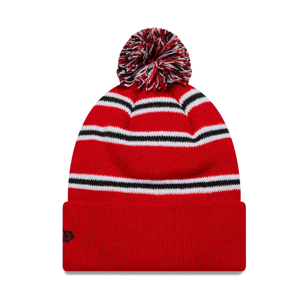 New Era Manchester United FC Infant Stripe Red Cuff knit Beanie Hat, front view showing the red knit fabric with white and black horizontal stripes, a red cuff adorned with the black New Era flag logo on the side, and a red, black.