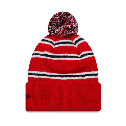 New Era Manchester United FC Infant Stripe Red Cuff knit Beanie Hat, front view showing the red knit fabric with white and black horizontal stripes, a red cuff adorned with the black New Era flag logo on the side, and a red, black.