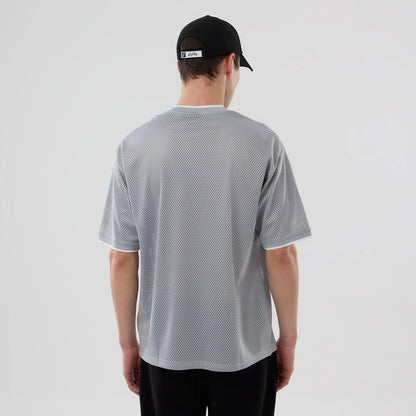 New Era San Antonio Spurs NBA Mesh Grey Oversized T-Shirt, back view on-model showing the textured grey mesh fabric throughout, short sleeves with white trim, and a relaxed fit that complements the black cap worn by the model.