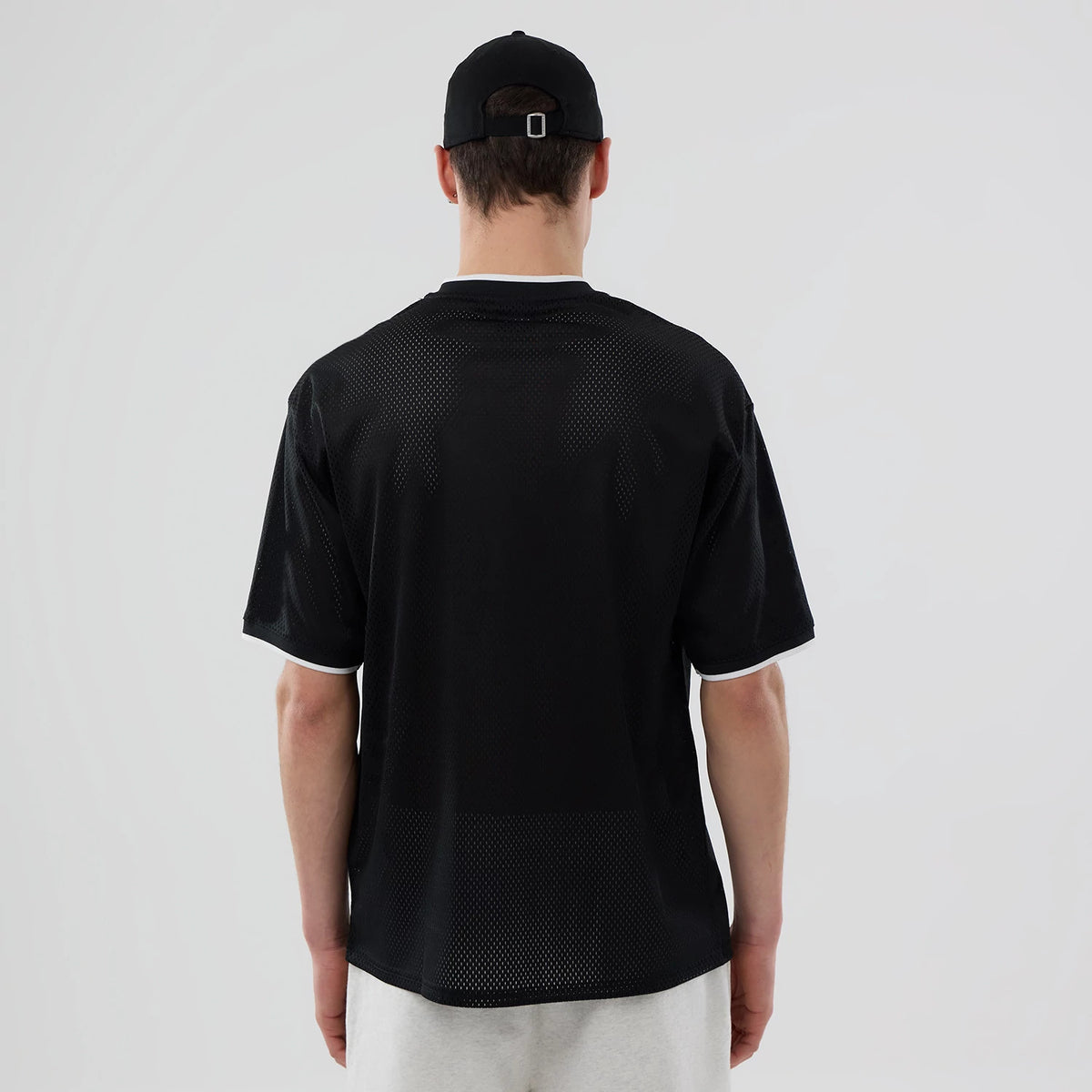 The model is wearing this NBA Mesh Chicago Bulls Oversized T-Shirt in black. 2