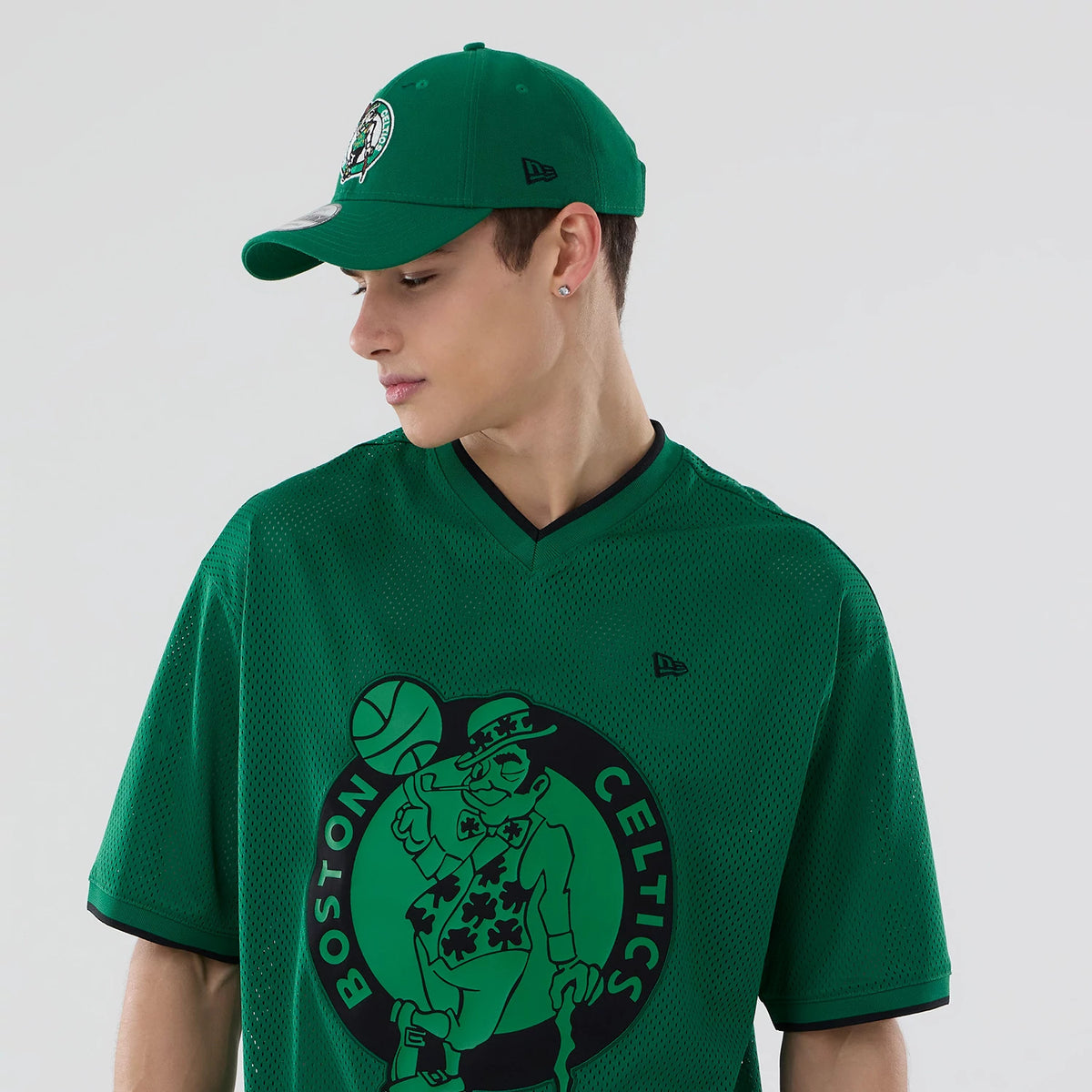 The model is wearing this NBA Mesh Boston Celtics Oversized T-Shirt in green. 6