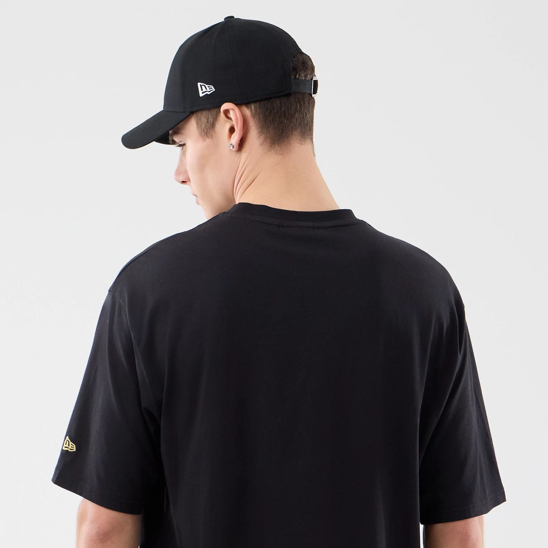 The model is wearing this New Era Sticker Porto Oversized T-Shirt in black. 7