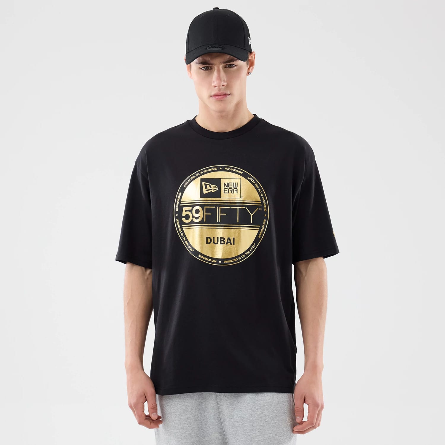 The model is wearing this New Era Sticker Dubai Oversized T-Shirt in black. 1