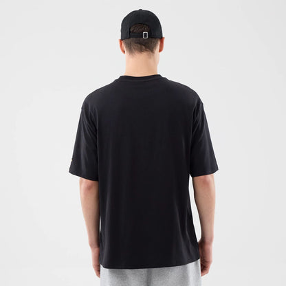 The model is wearing this New Era Sticker Dubai Oversized T-Shirt in black. 2