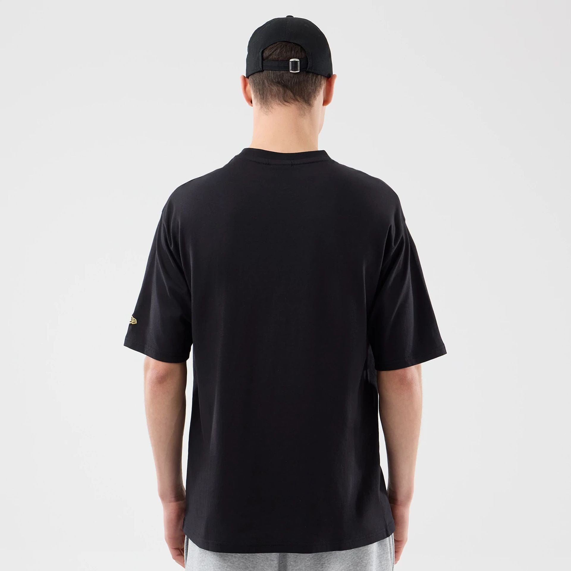 The model is wearing this New Era Sticker Lisbon Oversized T-Shirt in black. 2