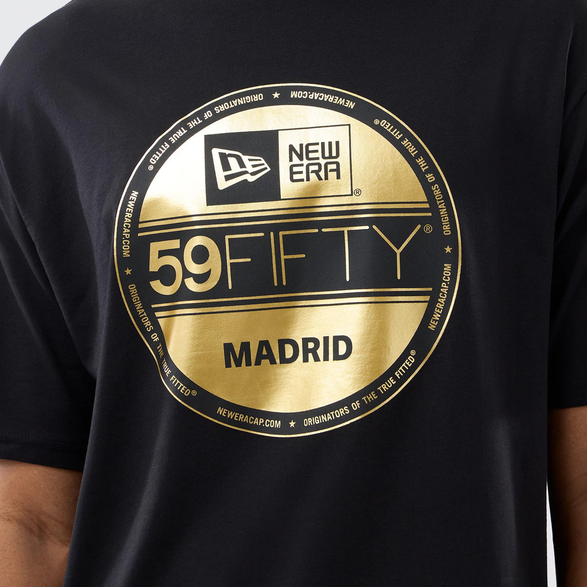 New Era Sticker Madrid Black Oversized T-Shirt, front view featuring a large gold printed circular graphic prominently displaying the New Era logo, 59FIFTY branding, and Madrid lettering at the centre on the black fabric.